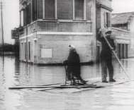Un uomo e una donna, vittime dell'alluvione, usano un relitto come zattera