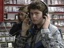 Un ragazzo, in primo piano, e una ragazza ascoltano in cuffia musica in un negozio di dischi. Fotogramma tratto dalla trasmissione 'Finestre'