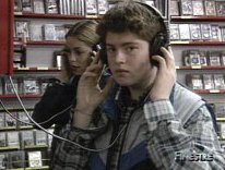 Un ragazzo, in primo piano, e una ragazza ascoltano in cuffia musica in un negozio di dischi. Fotogramma tratto dalla trasmissione 'Finestre'